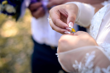Bride with French manicure holding a daisy