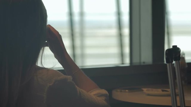 Female drinking coffee at table in airport cafe, holiday trip, travelling abroad