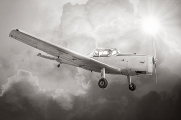 vintage propeller airplane on cloudy sky background