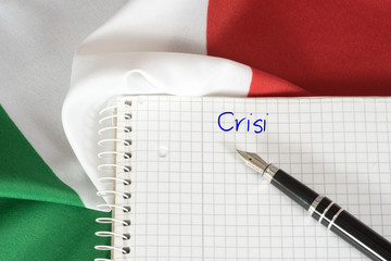 Flagge von Italien und ein Heft mit dem italienischen Wort für Krise
