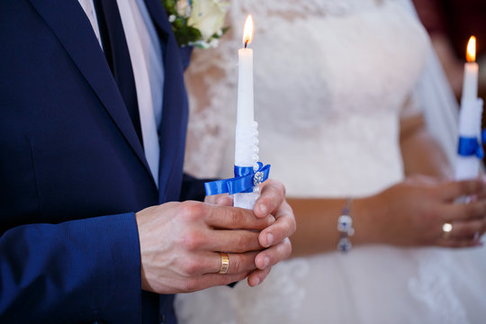 Wedding couple holding candles at the wedding ceremony in the Christian church