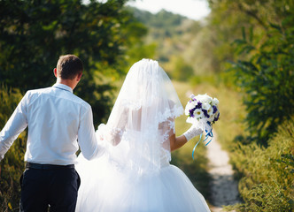 loving couple walking in the park on their wedding day