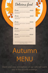 Autumn menu. Plate with yellow leaves Rowan. On a wooden table.