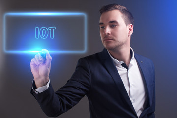 The concept of business, technology, the Internet and the network. Young businessman showing inscription: IOT