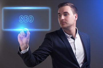 The concept of business, technology, the Internet and the network. Young businessman showing inscription: SEO