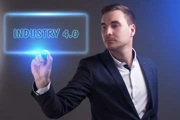 The concept of business, technology, the Internet and the network. Young businessman showing inscription: Industry 4.0