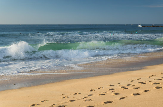 close up on breaking wave coming to shore on sandy beach of atlantic coast, capbreton, france