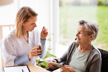 Health visitor and a senior woman with tablet.