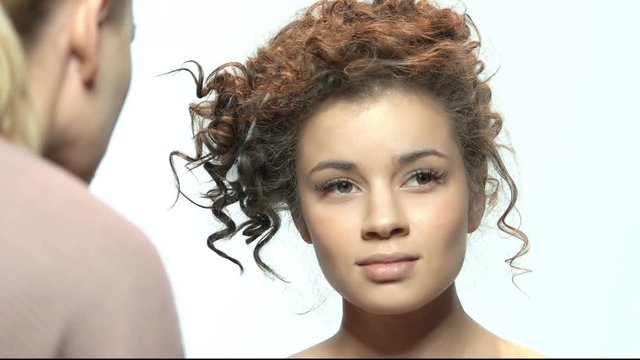 Visagist with brush applying makeup. Pretty young model. Easy makeup tutorial for beginners.