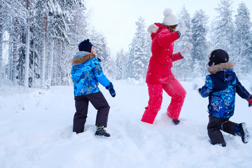 Happy mother with her children playing in a snow