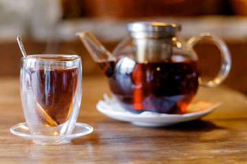 Turkish tea in traditional glass with nuts on grey table closeup