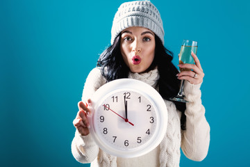 Young woman holding a clock showing nearly 12