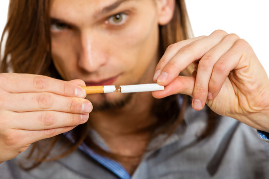 Young man is breaking a cigarette