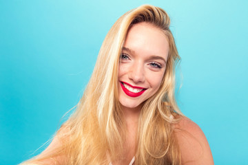 Fototapeta premium Young woman taking a selfie on a solid background