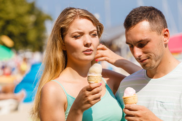 Man and woman eating ice cream on beach
