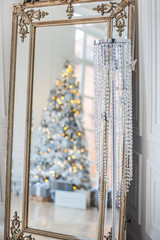 Новогодняя елка и подарки под елкой отражаются в большом зеркале