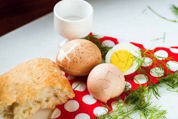 Hard boiled egg, bread and napkin on table.