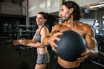 Man and woman fitness partners exercise together with medicine ball training for core