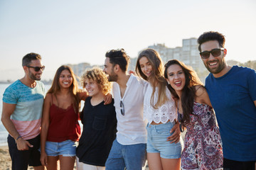 Happy group of friends standing together in row outside