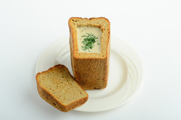 Mashroom crean soup in bread decorated greens isolated on white background
