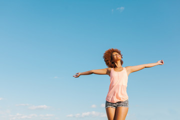 Latin American Afro Woman with Arms Wide Open in a Radiant Summer Day