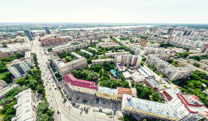 Aerial city view with crossroads and roads, houses, buildings, parks and parking lots, bridges. Helicopter drone shot. Wide Panoramic image.