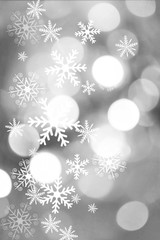 Fototapeta na wymiar Silver, beautiful blurred bokeh lights for Christmas and New Year celebration. Magical abstract glittery backgroun with falling snowflakes.