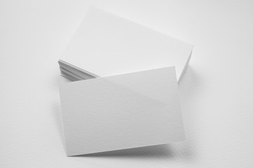 Stack of blank business card with one card in front on white background