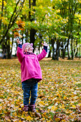 happy little child, baby girl laughing and playing in the park at autumn on the nature walk outdoors