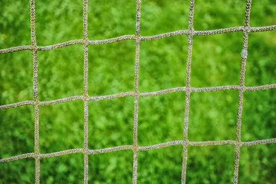 Picture of football net with green grass at the background