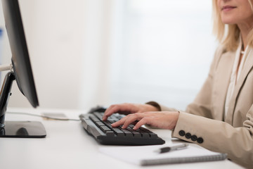 Mature businesswoman using her desktop computer in the office