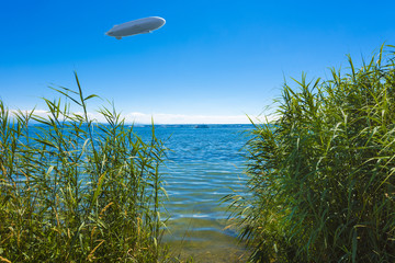 View through the reed to Lake Constance near Immenstaad with zeppelin - Immenstaad, Lake Constance, Baden-Wuerttemberg, Germany, Europe © karlo54