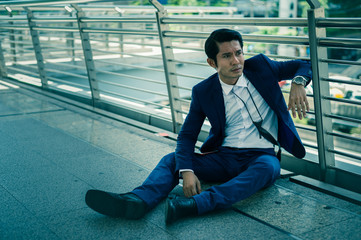 businessman unemployed from company sitting on the street, concept of business failure and unemployment problem