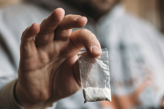 Man hand holding cocaine or other drugs, drug abuse