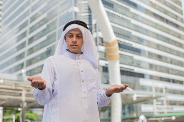 Muslim man praying in public place and modern building background