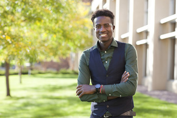 Handsome confident young black student man smiles on college campus
