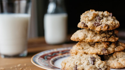Chocolate chip oatmeal cookies on a plate and glass of milk