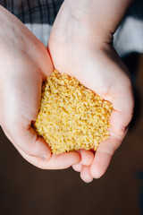 Woman holding natural organic bulgur cereal in hands.