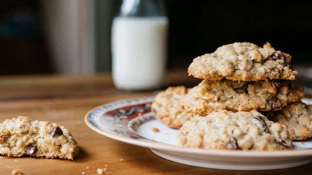 Stack of oatmeal cookies on a plate and bottle of milk