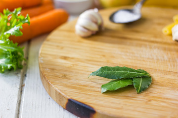 Bay leaves over wooden board