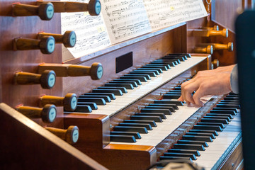 Close up view of a organist playing a pipe organ