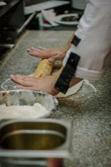 Obraz na płótnie Canvas Chef preparing dough for pizza at italian pizzeria.