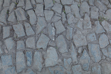 Abstract background of old cobblestone pavement close-up.