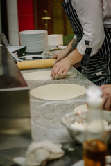 Fototapeta na wymiar Chef preparing dough for pizza at italian pizzeria.