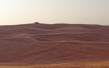 Fototapeta na wymiar Safari vehicle on the skyline at sunset in the desert outsideDubai City, United Arab Emirates