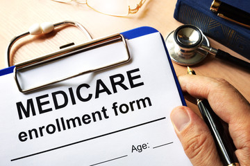 Medicare enrollment form in a hand. - obrazy, fototapety, plakaty