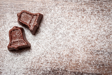Chocolate candy in shape of Christmas bell with powdered sugar