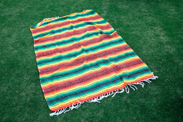 Brightly colored blanket on green grass