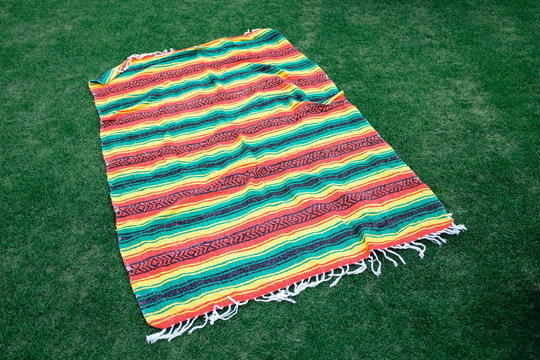 Brightly colored blanket on green grass