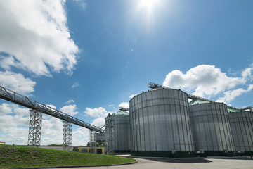 High metal silos for storage of wheat and barley. Sunny day, the blue sky. © nordroden
